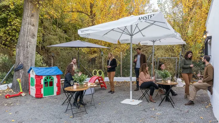 Reunión al aire libre bajo sombrillas entre los árboles